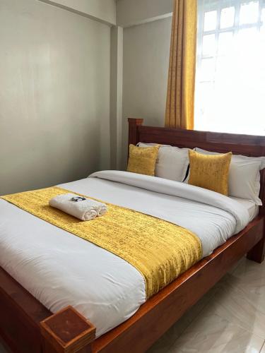 a bedroom with a large bed with a yellow blanket at The comfortplace 303 Oak in Kericho