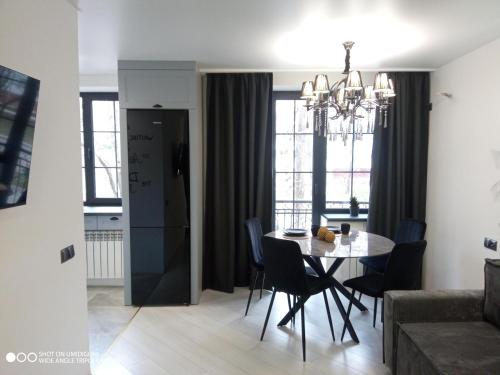 a dining room and living room with a table and chairs at Lovely apartment in Tiraspol