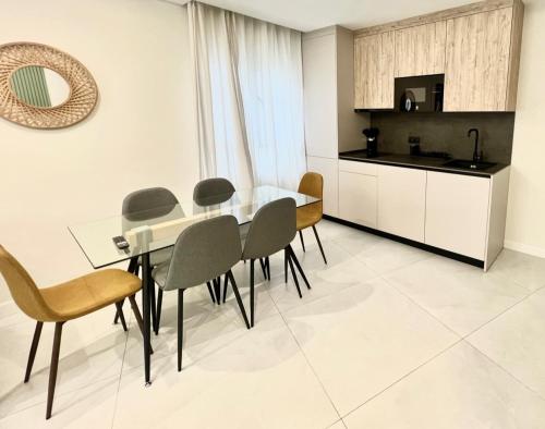 cocina y comedor con mesa de cristal y sillas en Apartamento El Cardenal, en Córdoba