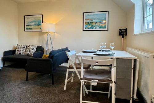 ein Wohnzimmer mit einem Tisch und einem Sofa in der Unterkunft CENTRAL, newly refurb 2 bed flat with FREE PARKING in Cambridge