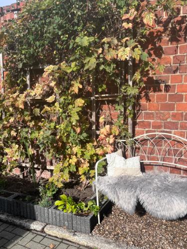 a bench sitting in a garden next to a brick wall at HEIMATliebe Ferienhaus für 4 in Blankenhain