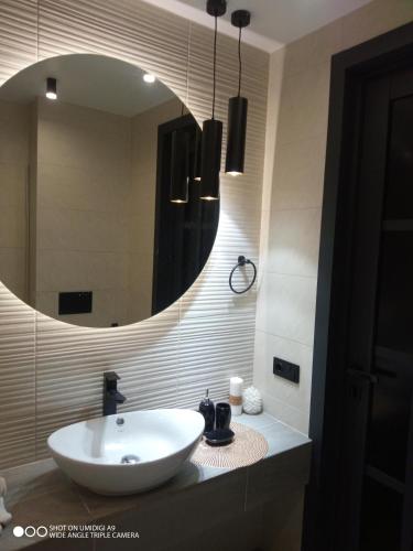 a bathroom with a white sink and a mirror at Lovely apartment in Tiraspol