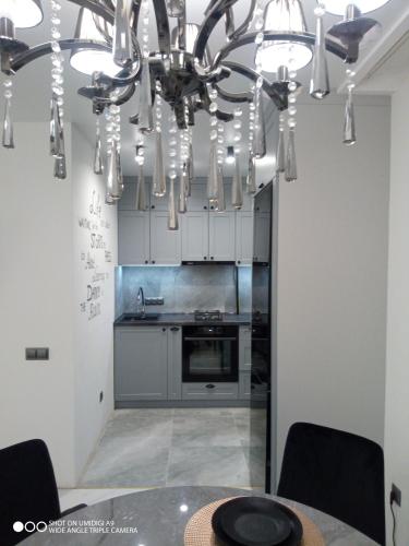 a kitchen with a dining table and a chandelier at Lovely apartment in Tiraspol