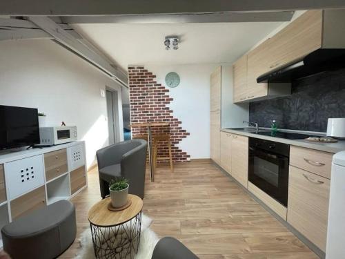 une cuisine avec une table et des chaises dans une pièce dans l'établissement Edouard 2. logement complet., à Charleville-Mézières