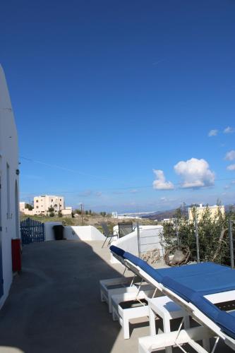 a group of lounge chairs and a surfboard on a balcony at Villa Solasta in Santorini in Akrotiri