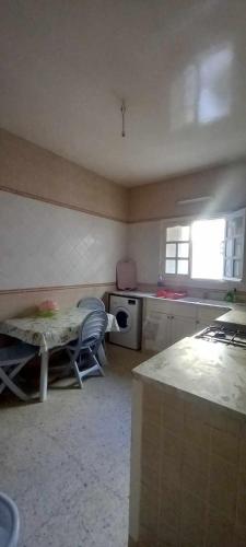 a kitchen with a table and a window in it at Le Kram House in La Goulette