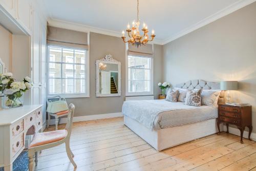 a bedroom with a bed and a dresser and a mirror at Victoria Belgravia Apartments in London