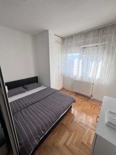 Habitación pequeña con cama y ventana en Apartment 4th. Floor, en Banja Luka