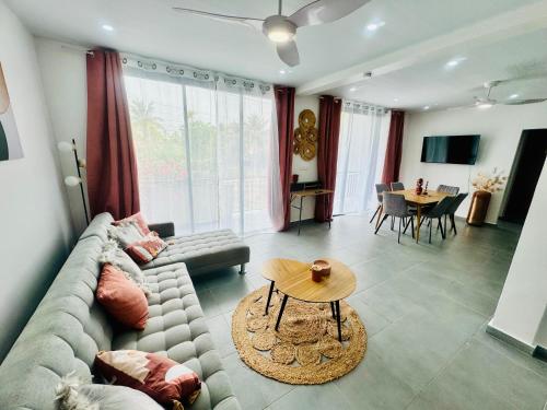 ein Wohnzimmer mit Couch und Tisch in der Unterkunft L’oasis douceur in Montjoly