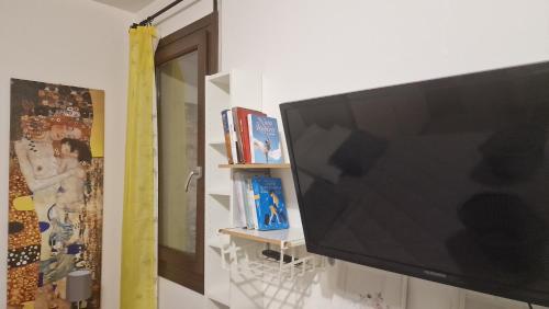 TV de pantalla plana grande colgada en la pared en City Cottage en Reggio Emilia