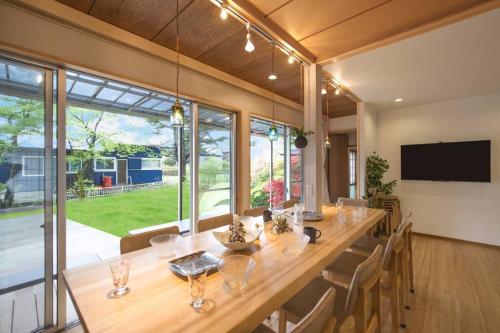 een grote eetkamer met een lange tafel met stoelen bij Private hot-spring Villa in Kusatsu in Kusatsu