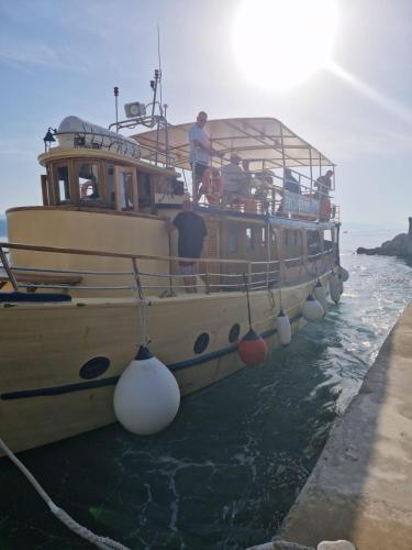 a boat parked on the water with people on it at Apartment Lady Daniela mit Meerblick in Lovran in Lovran