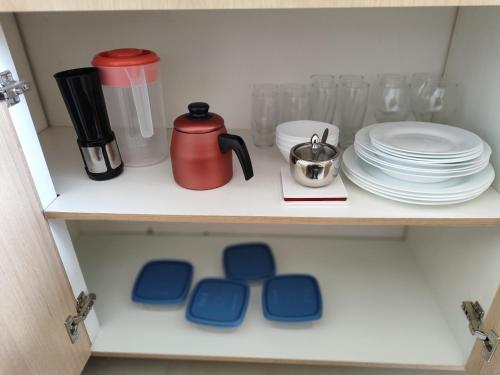 a shelf with plates and a coffee pot and dishes at A uma quadra da praia de Copacabana in Rio de Janeiro