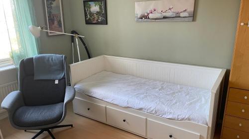 a bed and a chair in a room at Rum för övernattning in Trollhättan