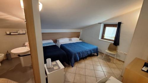 - une petite chambre avec un lit bleu et un lavabo dans l'établissement B&B Villa Maria Paola - Alloggi Temporanei Isernia, à Isernia