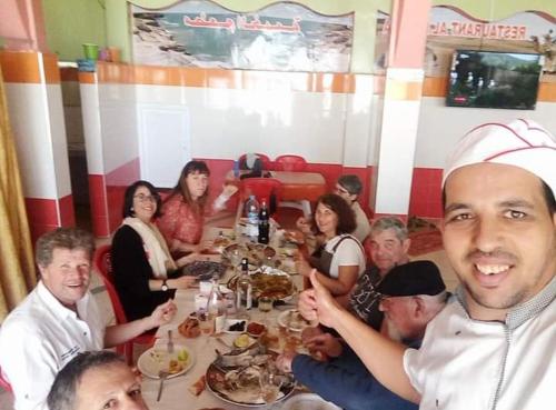 a group of people sitting around a table eating at Raji Residence in Akhfennirr