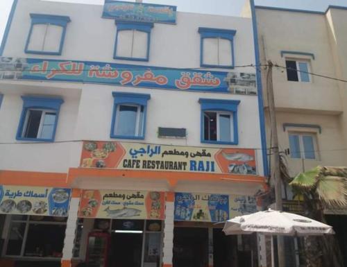 a building with an umbrella in front of it at Raji Residence in Akhfennirr
