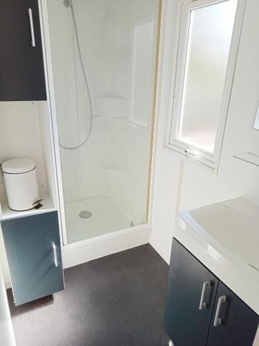 une salle de bain avec une douche avec une porte vitrée dans l'établissement Spacieux Mobil-Home Fréjus, à Fréjus