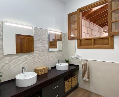 een badkamer met 2 wastafels en 2 spiegels bij Casa América in Sabina Alta