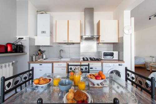 une cuisine avec une table avec des bols de fruits dessus dans l'établissement Port et Littoral * Proche plage * Central * loggia, à La Grande Motte