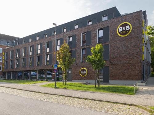 ein Backsteingebäude mit einem Schild an der Seite in der Unterkunft B&B Hotel Kiel-Wissenschaftspark in Kiel