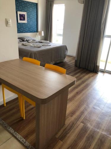1 dormitorio con 1 cama, mesa y sillas en Studio Moderno bem localizado en Feira de Santana