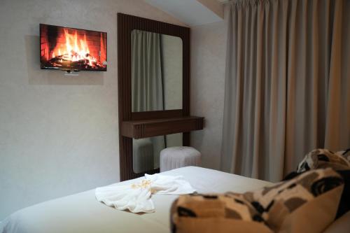 1 dormitorio con cama, espejo y TV en Le Rocher De L'Atlas, en Azrou
