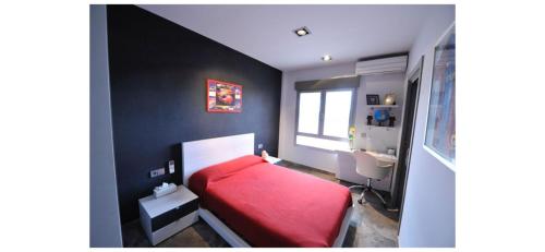 1 dormitorio con cama roja y lavamanos en VILLA CAMPO PREMIUM en Yecla
