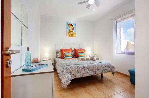 sypialnia z łóżkiem, stołem i oknem w obiekcie Villa Amistad w mieście La Oliva