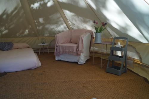 una habitación con una silla y una mesa en una tienda de campaña en Camping sous les belles etoiles, en Peyrilhac