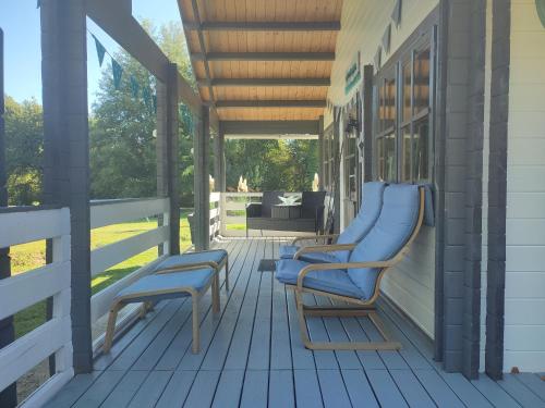 un porche con 2 sillas azules en una casa en Camping sous les belles etoiles, en Peyrilhac