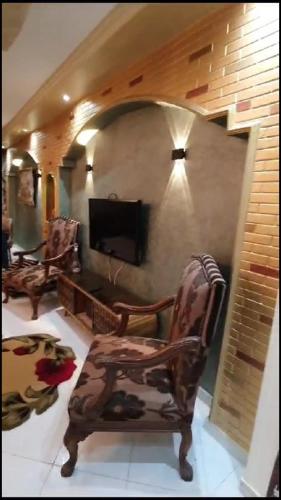 a living room with a chair and a tv at شقة مفروشة فاخرة بأرقى مواقع المنصورة in Mît Khamîs