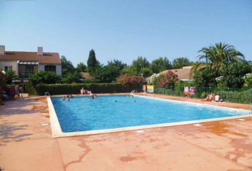 une grande piscine avec des gens dans l'eau dans l'établissement Maisonnette climatisée 6 personnes, à Argelès-sur-Mer