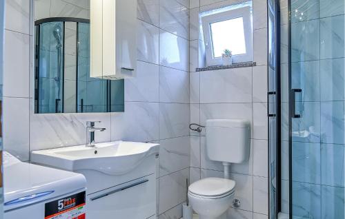 een witte badkamer met een toilet en een wastafel bij Awesome Home In Rukavac With Wi-fi in Rukavac