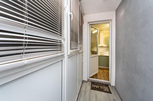 um corredor com uma porta e uma janela com persianas em Квартира студия 1 комнатная на Теремках низкий этаж em Kiev
