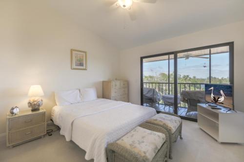 a bedroom with a large bed and a balcony at LAKE PALMS 1 in Sanibel
