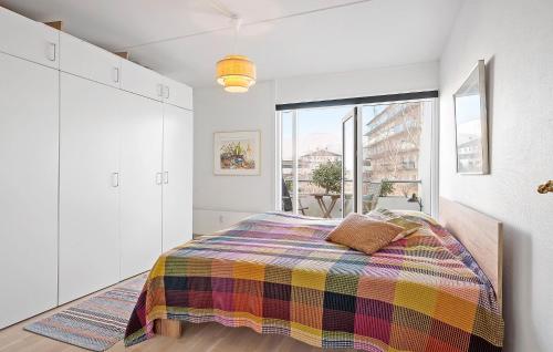 赫爾辛格的住宿－Beautiful Apartment In Helsingr With Wifi，一间卧室配有一张带彩色毯子的床