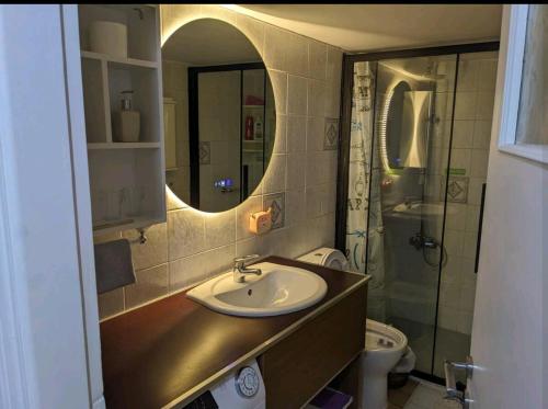 a bathroom with a sink and a toilet and a mirror at Harbor View Haven in Piraeus