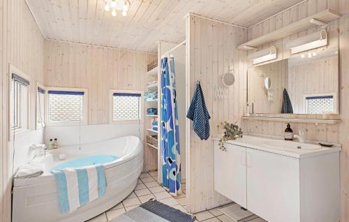 Baño blanco con bañera y lavamanos en 3 Bedroom Nice Home In Hornbk, en Hornbæk