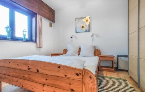 een slaapkamer met een houten bed en een raam bij Beautiful Apartment In Bredene With Kitchen in Bredene