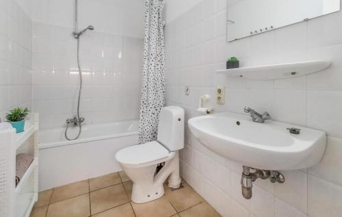 een witte badkamer met een toilet en een wastafel bij Beautiful Apartment In Bredene With Kitchen in Bredene