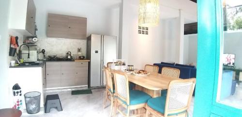 a kitchen with a wooden table and chairs in a kitchen at casa idea ubud in Ubud