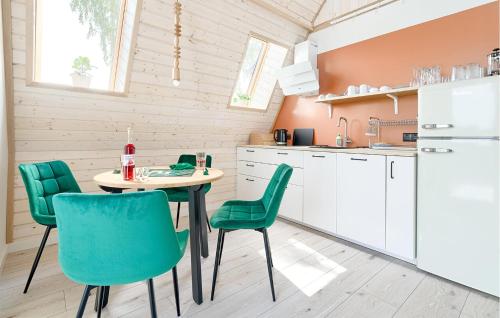 a kitchen with a table and green chairs at Cozy Apartment In Tlen With Kitchen in Tleń