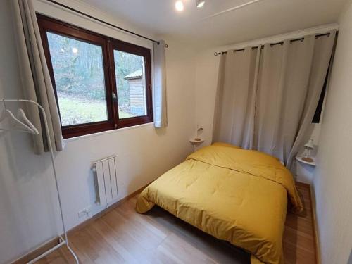 um quarto com uma cama amarela e uma janela em Le Refuge Martin em Les Mazures