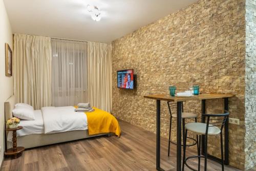 - une chambre avec un lit et un mur en briques dans l'établissement Квартира студия 1 комнатная на Теремках низкий этаж, à Kiev