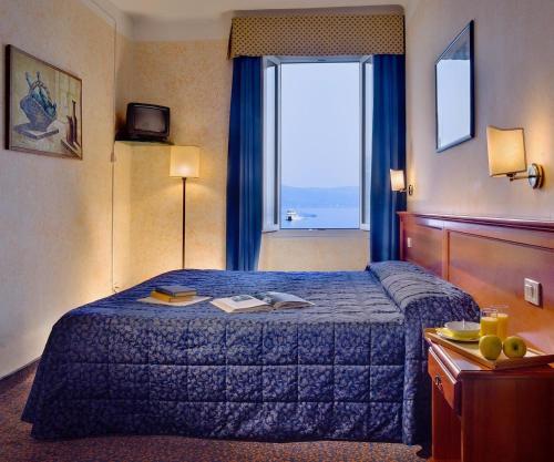 a hotel room with a bed and a large window at Hotel Garnì Riviera in Gargnano