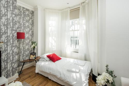 a bedroom with a white bed and a window at Marvellous Flat in Earls Court in London