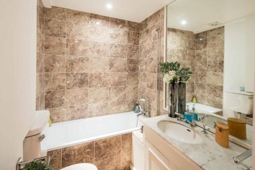 een badkamer met een wastafel, een bad en een toilet bij Marvellous Flat in Earls Court in Londen