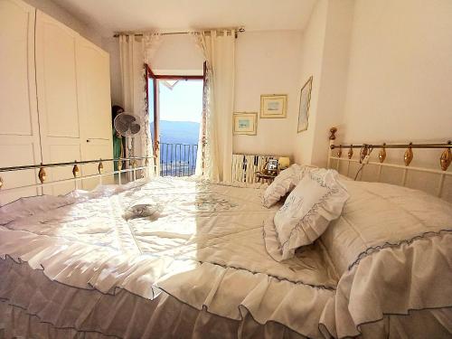 a large bed in a bedroom with a window at La Maison des Rèves -Langhe Piemonte in Torre Bormida