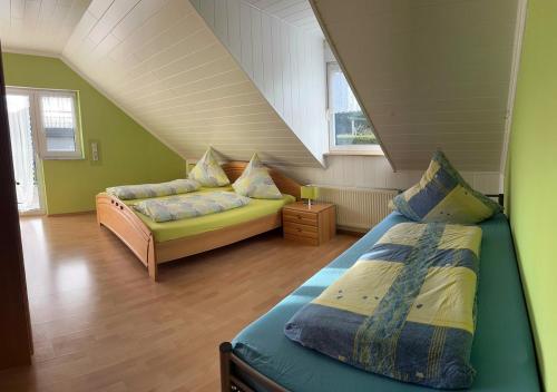 a attic bedroom with two beds and a couch at Ferienwohnung Hochwaldblick 1 in Morbach
